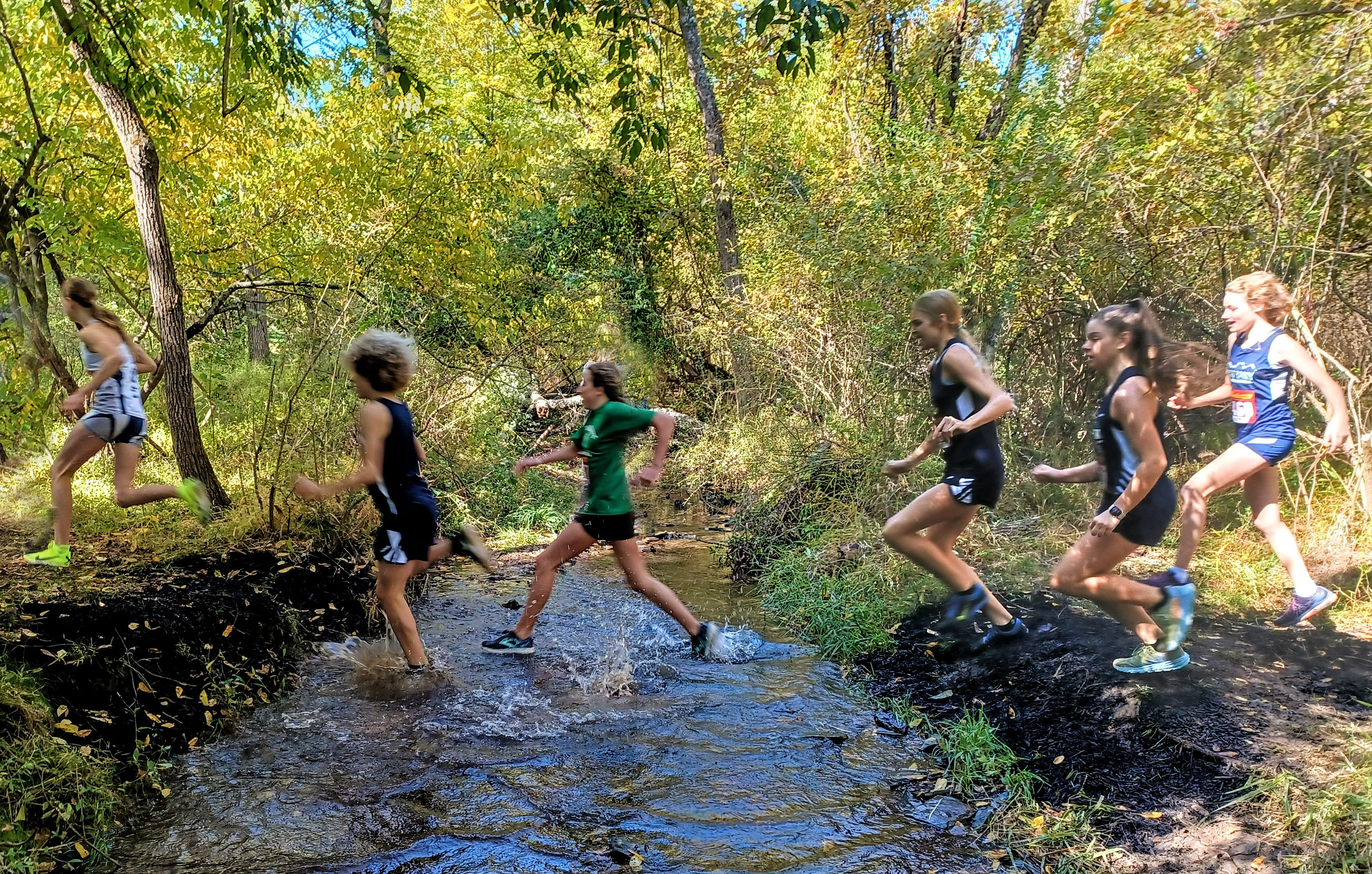 Runners crossing creek